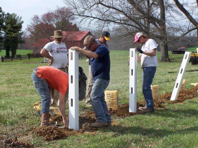 White Vinyl 3 Rail Installation - Hard at work setting post in concrete.